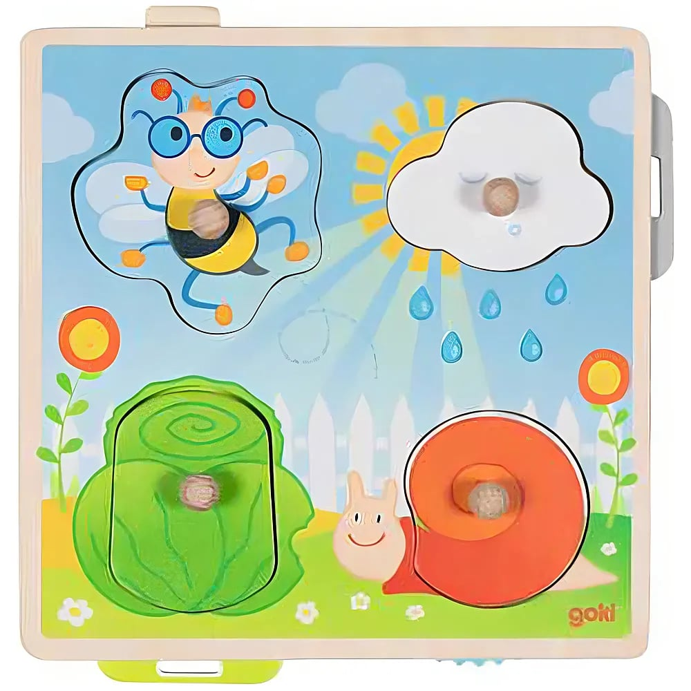 Buntes Holzspielzeug mit Biene, Wolke, Sonne, Schnecke und Salat auf blauer Wiese mit weißem Zaun.