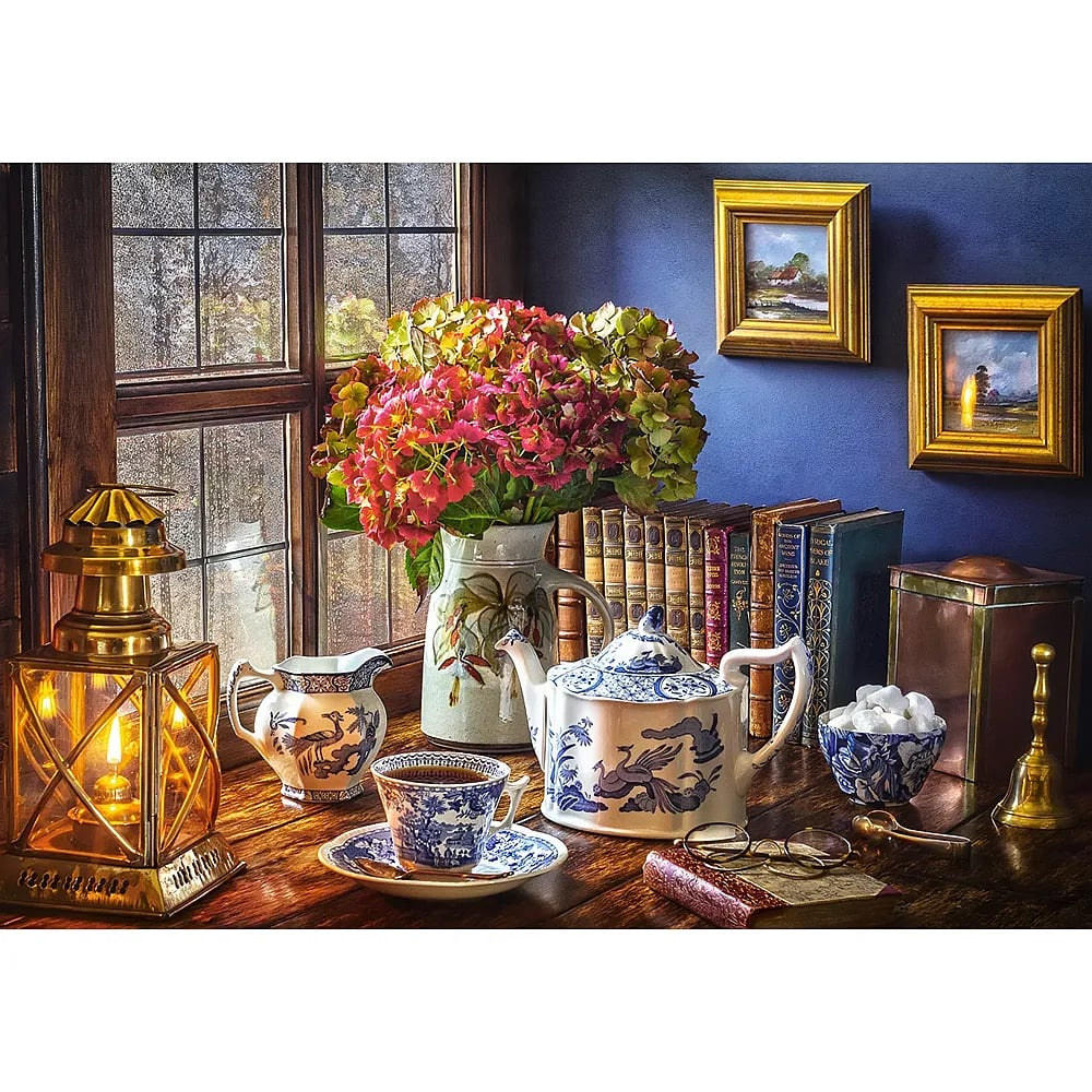 Naturaleza muerta con linterna, porcelana azul y blanca, flores, libros y cuadros contra una pared azul.