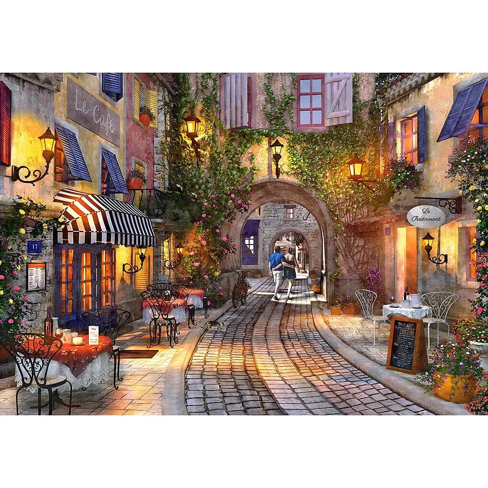 Beleuchtete Gasse in einer europäischen Altstadt mit Cafés, Blumen und einem Paar, das durch einen Torbogen geht.