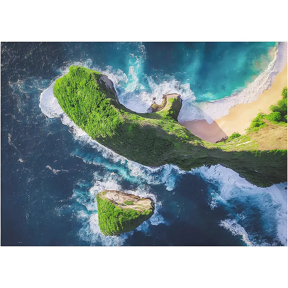 Vista aerea di una scogliera verde nel mare blu profondo con onde bianche e una spiaggia sabbiosa.