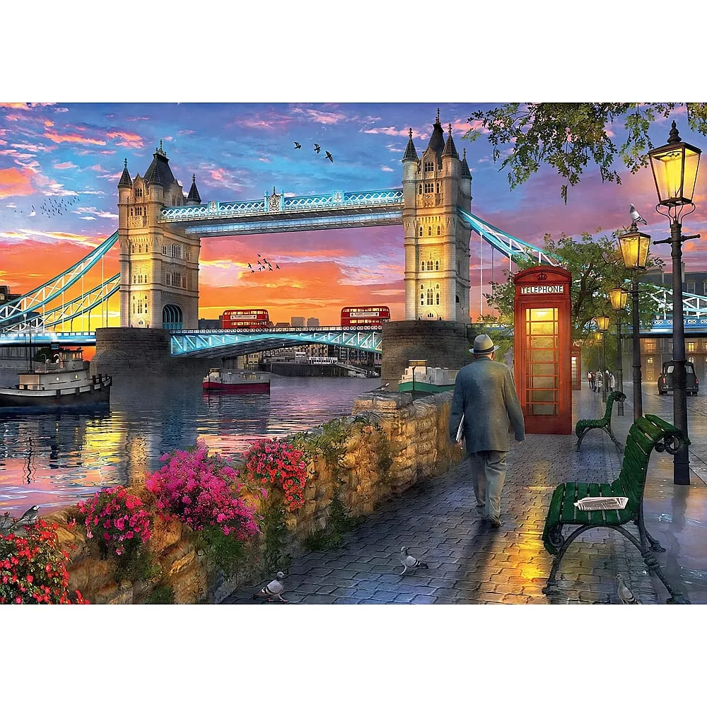Ein Mann geht bei Sonnenuntergang nahe der Tower Bridge in London an einer roten Telefonzelle vorbei.