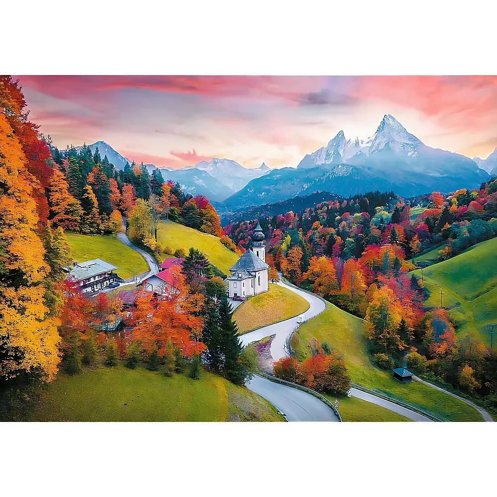 Autumn alpine landscape with a church, winding roads, colorful trees, and snow-capped mountains in the background.