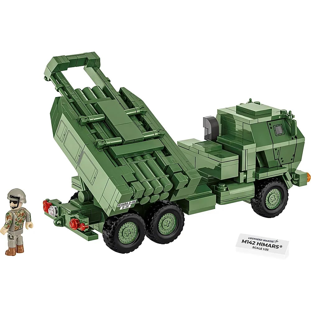 Un jouet de construction vert M142 HIMARS avec une petite figurine de soldat à gauche et une plaque signalétique.