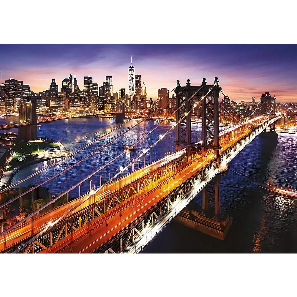 Vista nocturna del Puente de Manhattan con tráfico iluminado y el horizonte de Nueva York al fondo.