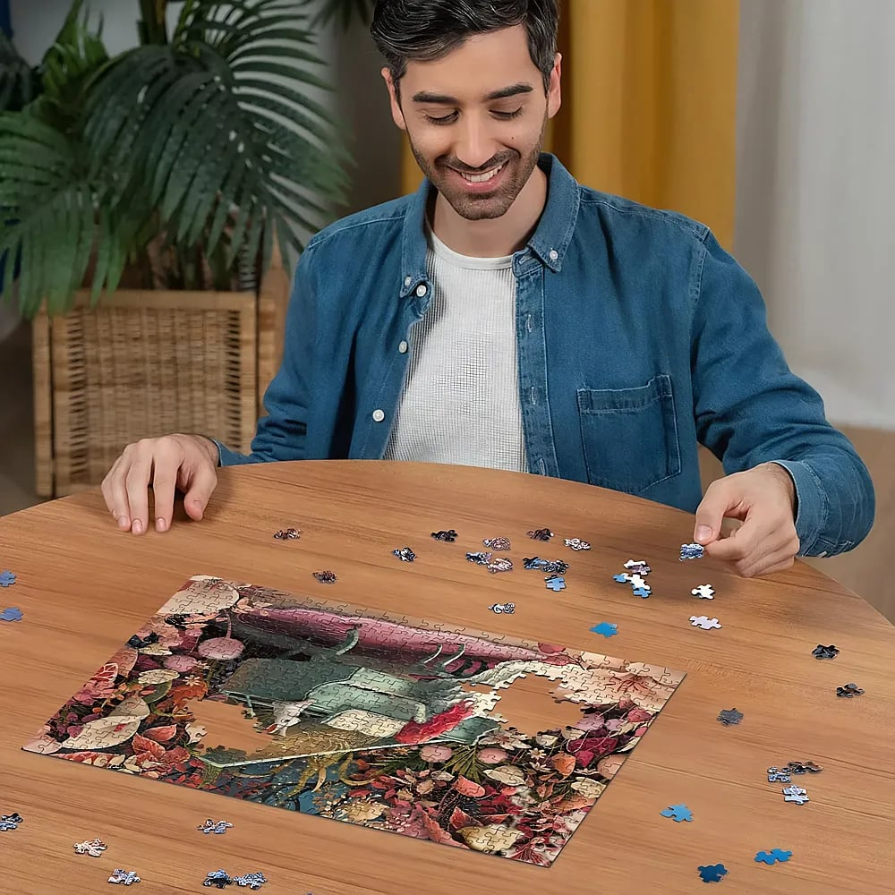 Ein lächelnder Mann sitzt am Holztisch und setzt ein farbiges Puzzle zusammen.