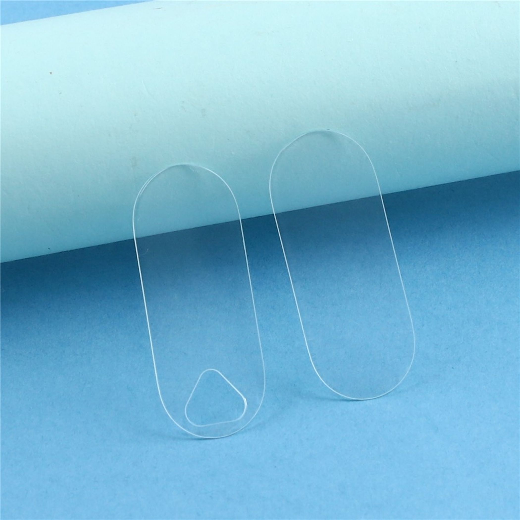 Zwei transparente Kamera-Displayschutzfolien auf blauem Hintergrund.