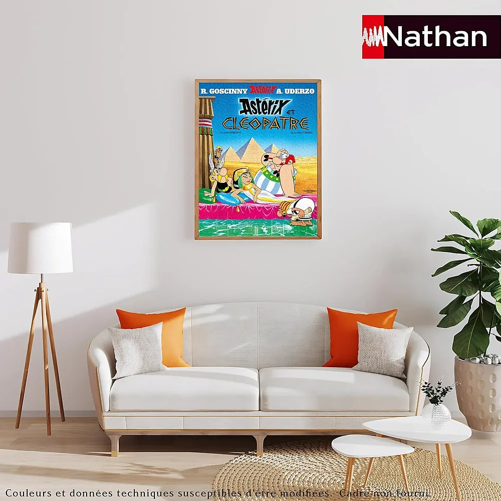 Wohnzimmer mit weißem Sofa, gerahmtem Asterix-Puzzle an der Wand, Stehlampe und Topfpflanze.