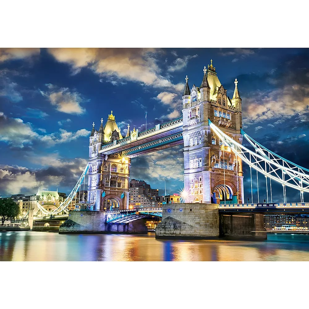 Die London Bridge ist nachts beleuchtet und spiegelt sich im darunter liegenden Fluss wider.
