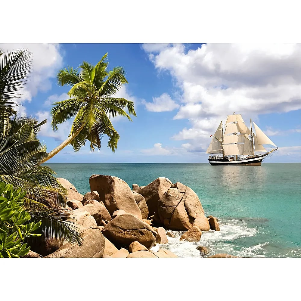 Ein großes Segelschiff fährt auf dem türkisblauen Meer an einer tropischen Küste mit Palmen und Felsen vorbei.
