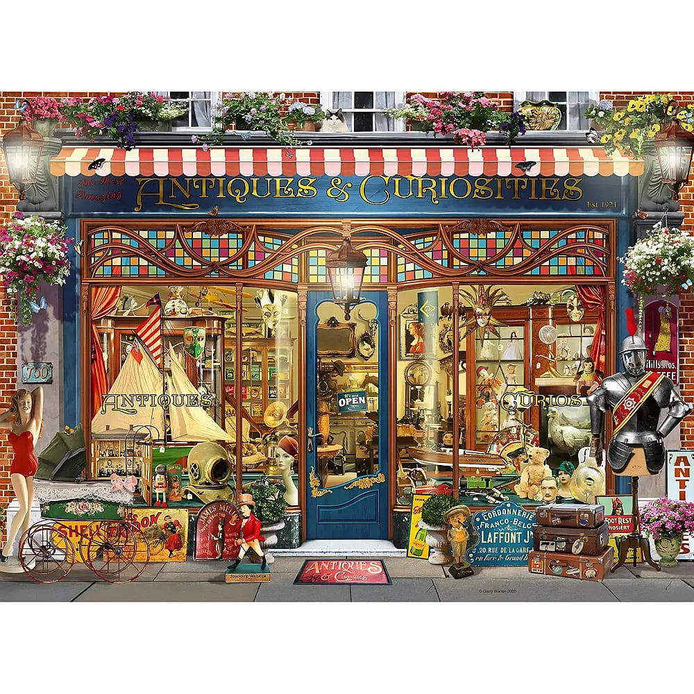 Antiquitätengeschäft mit Schild, buntem Schaufenster voller historischer Gegenstände und Blumenkästen oben.
