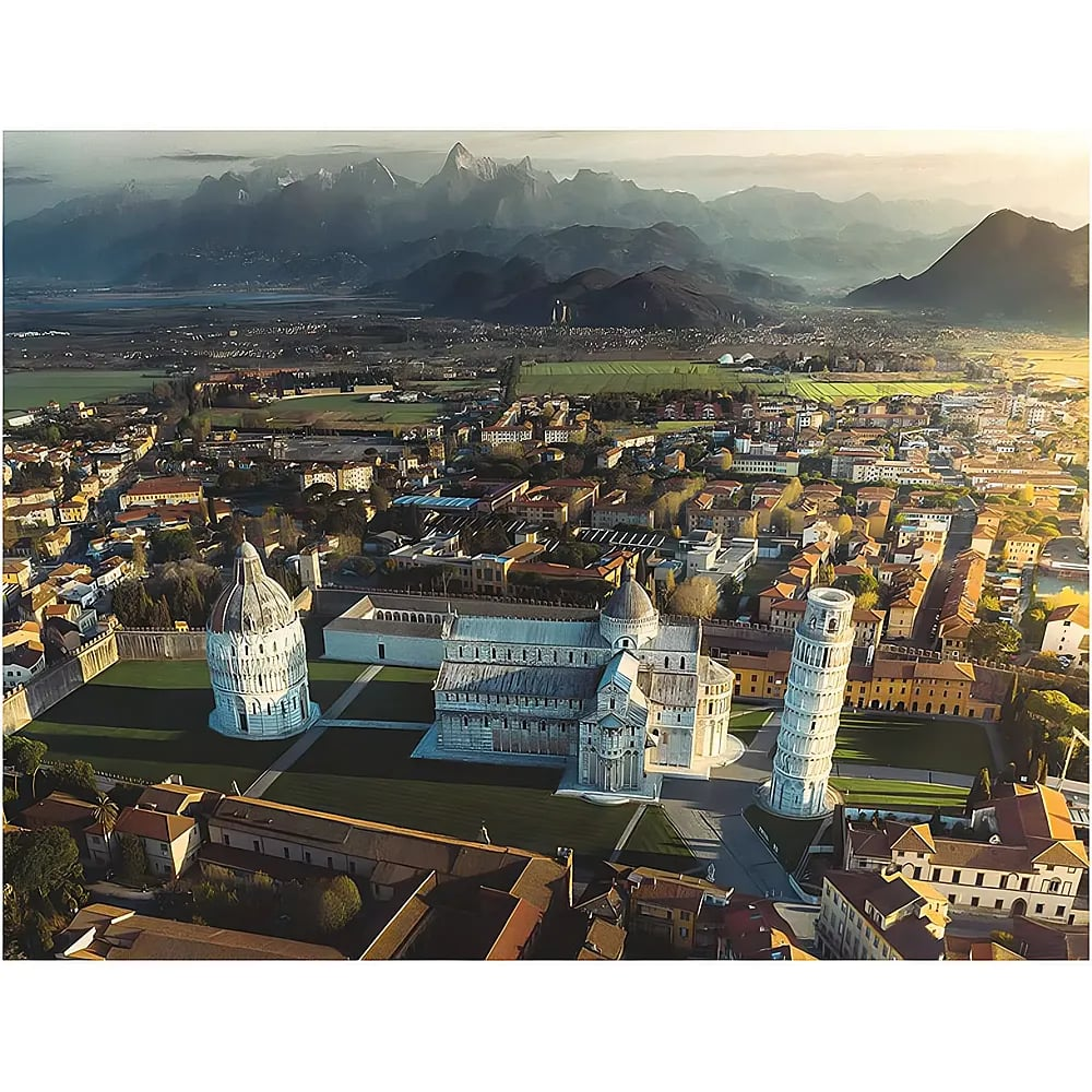 Luftaufnahme von Pisa mit dem schiefen Turm, dem Dom und der Stadt vor einer Bergkulisse.