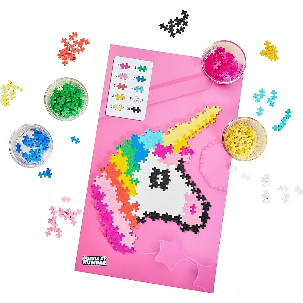 Un colorato mosaico di un unicorno fatto di pezzi a incastro su sfondo rosa, circondato da ciotole.