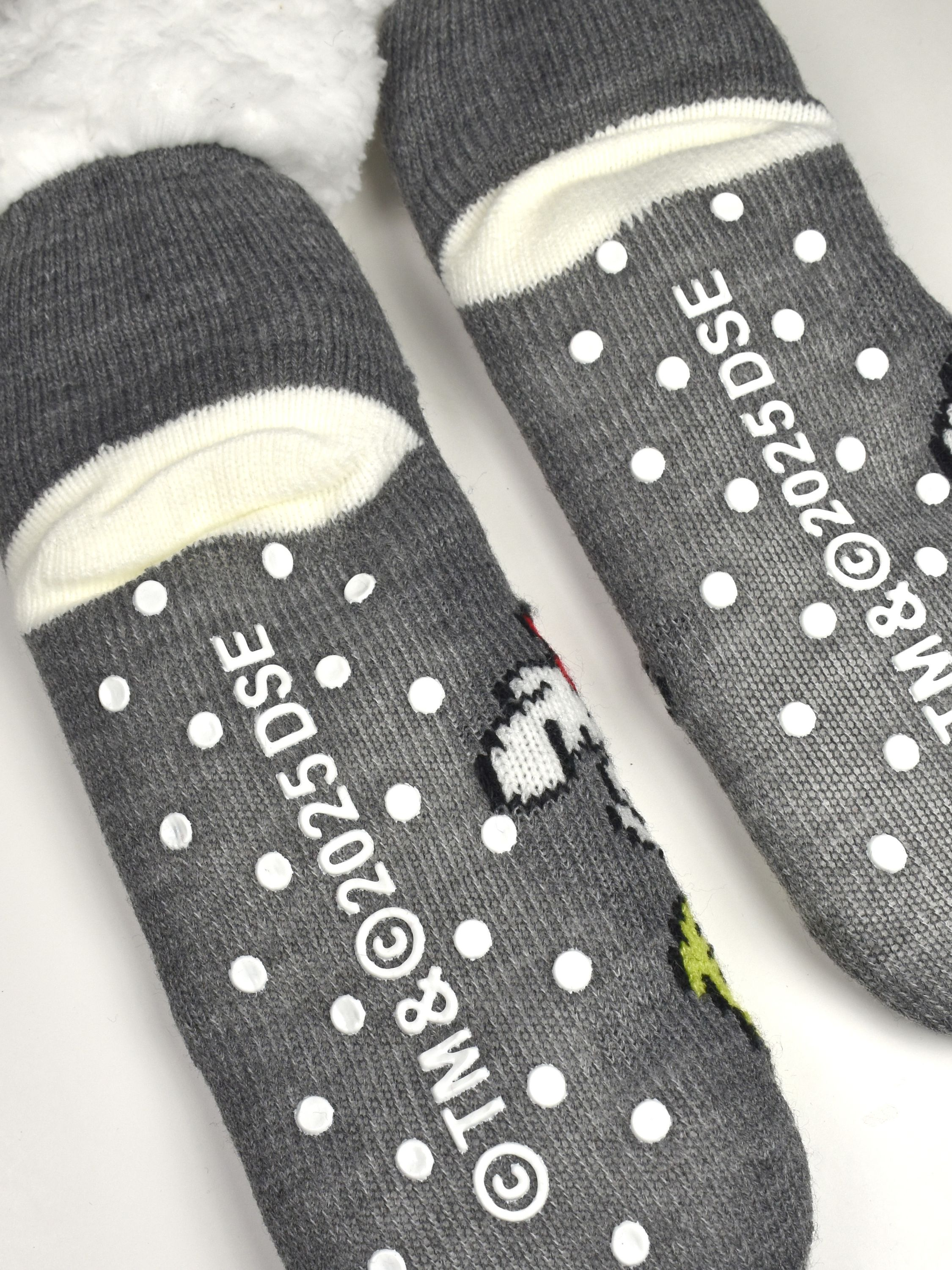 Graue Flauschsocken mit weißen Noppen auf der Sohle und Snoopy-Motiv.