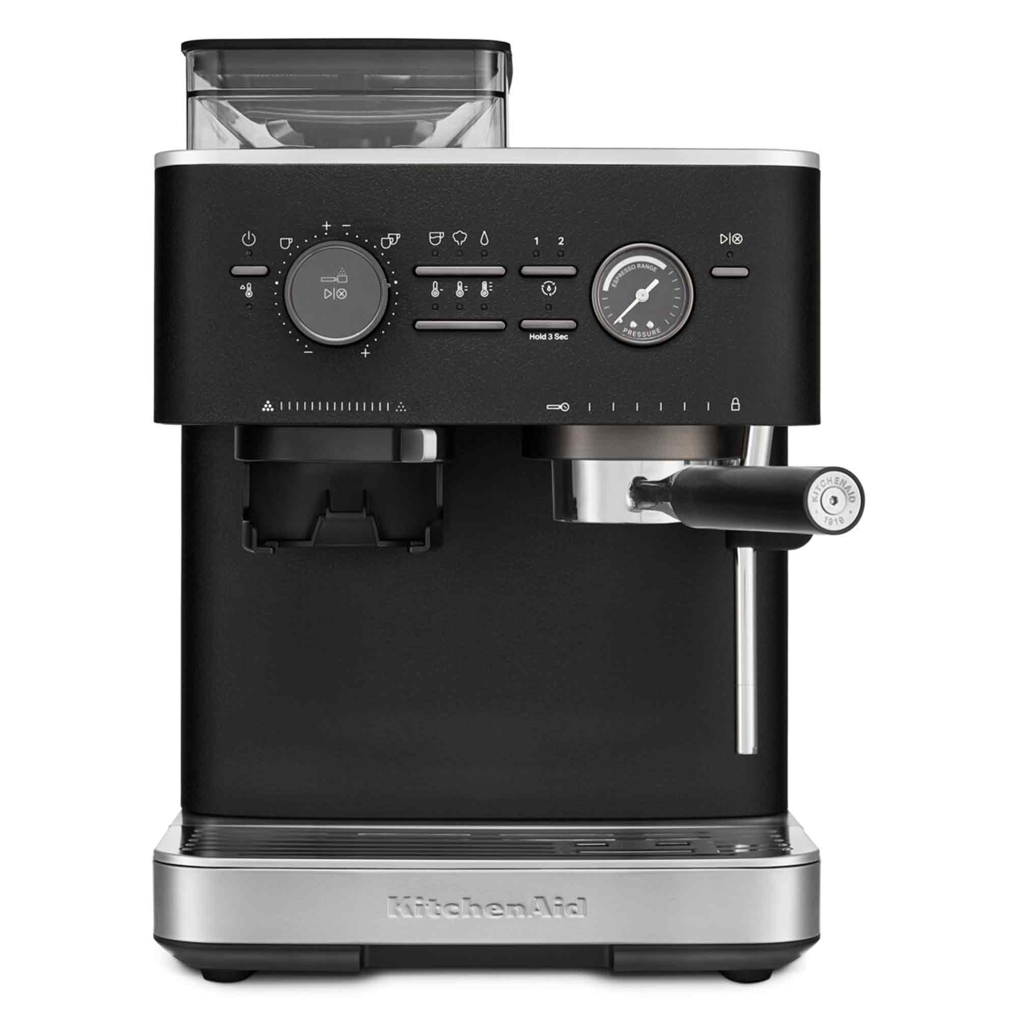 Czarny ekspres do kawy KitchenAid z pojemnikiem na ziarna, pokrętłami, manometrem i kolbą na srebrnej podstawie.
