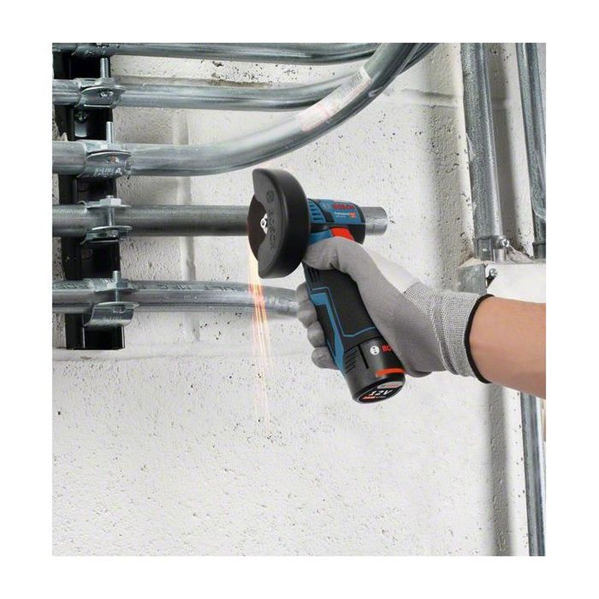 Eine handgeschützte Hand schneidet ein Metallrohr mit einer blauen Schleifmaschine ab, wobei Funken fliegen.