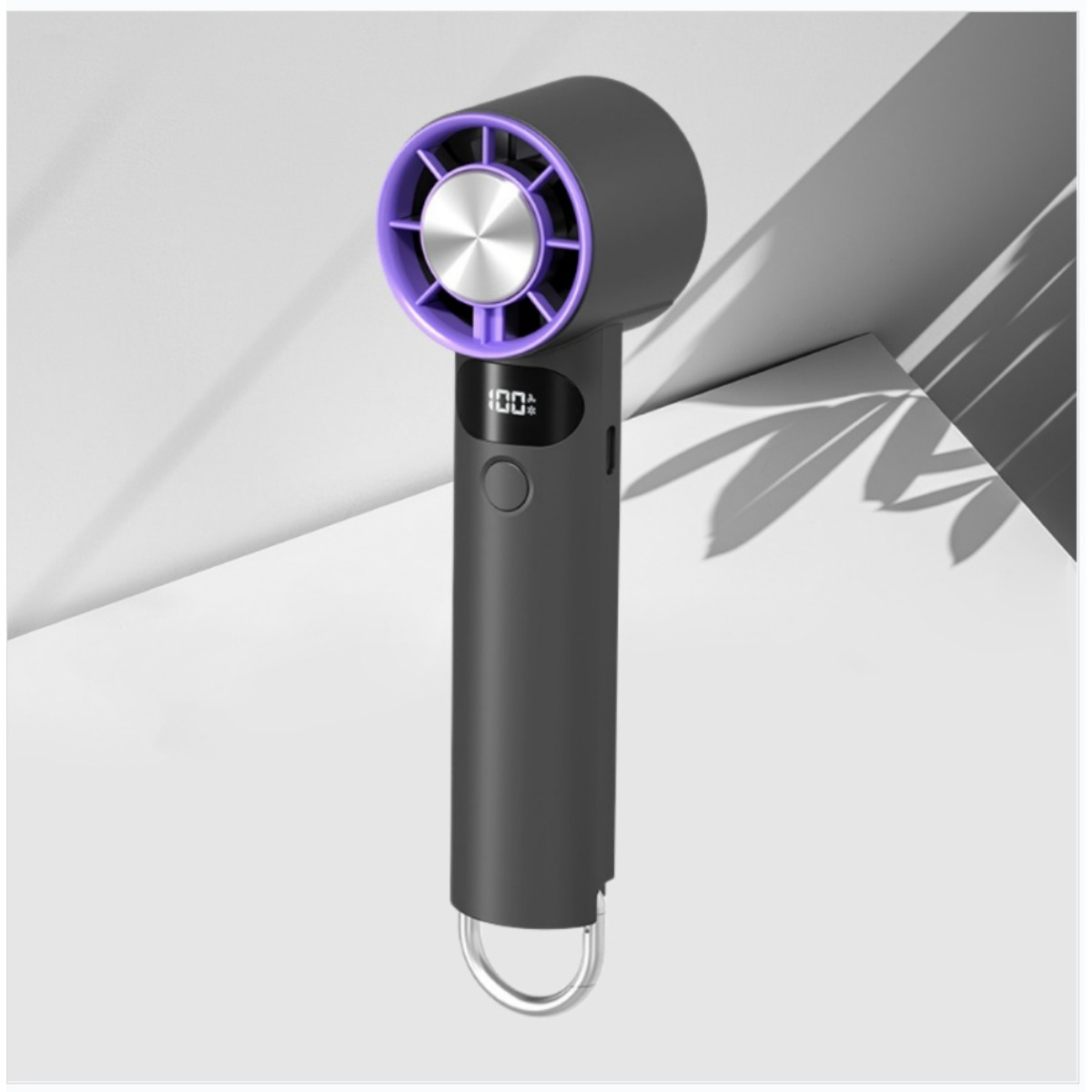 Ein dunkelgrauer Handventilator mit lilafarbenem Innenring, digitalem Display bei 100% und silbernem Metallclip.