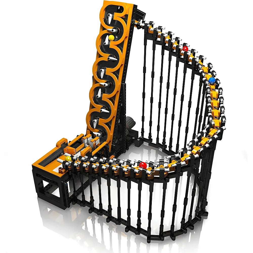 Un complesso modello di pista per biglie Lego nero e giallo con sfere colorate su superficie bianca.