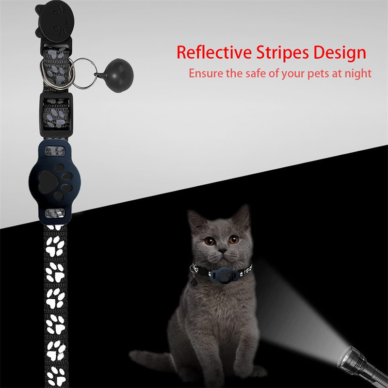 Reflektierendes Katzenhalsband mit Pfotenmuster, Glocke und Tracker-Halterung, in dunkler Umgebung von Taschenlampe beleuchtet.