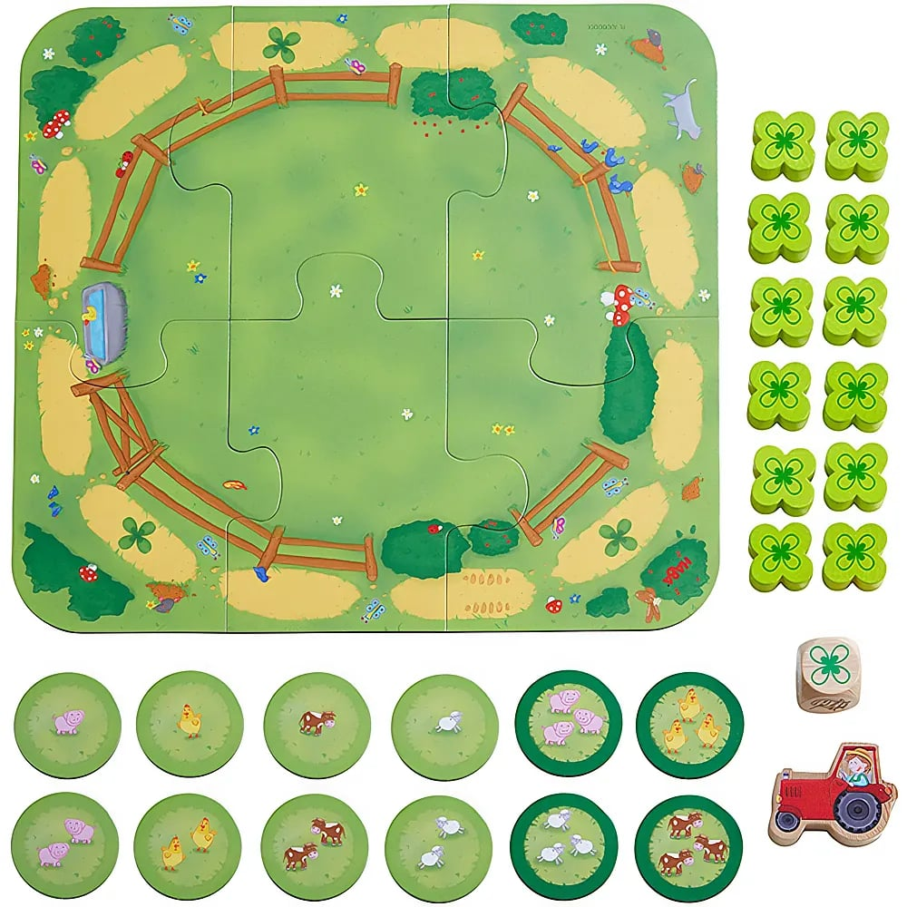 Ein Kinderspiel mit Weidenpuzzle, Tierchips, einem Würfel, Kleeblättern und einem Spielzeugtraktor.