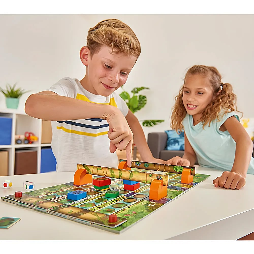 Zwei Kinder spielen gemeinsam an einem Tisch mit einem bunten Brettspiel.