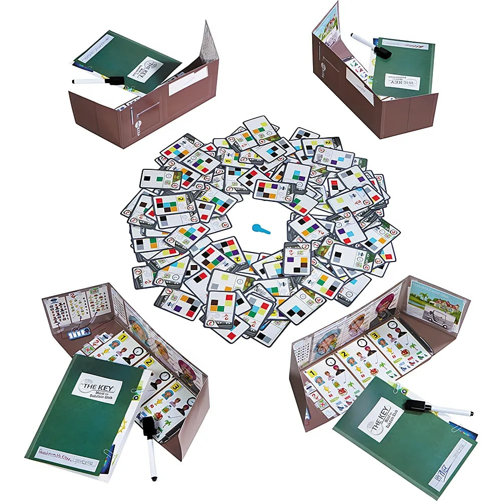 Ein Brettspiel mit Karten in der Mitte und vier Pappboxen mit Heften und Stiften an den Ecken.