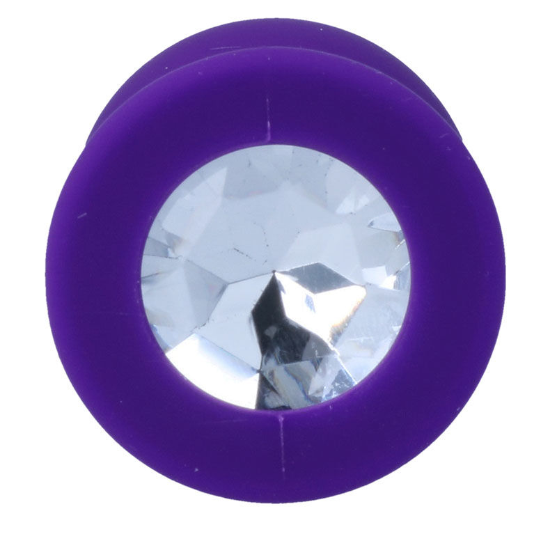 Lila Ohrpiercing mit glitzerndem, facettiertem weißem Kristall in der Mitte.