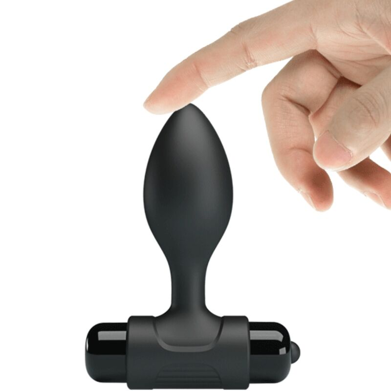 Eine Hand zeigt auf ein schwarzes, bauchiges Silikon-Massagegerät mit T-förmiger Basis vor weißem Hintergrund.