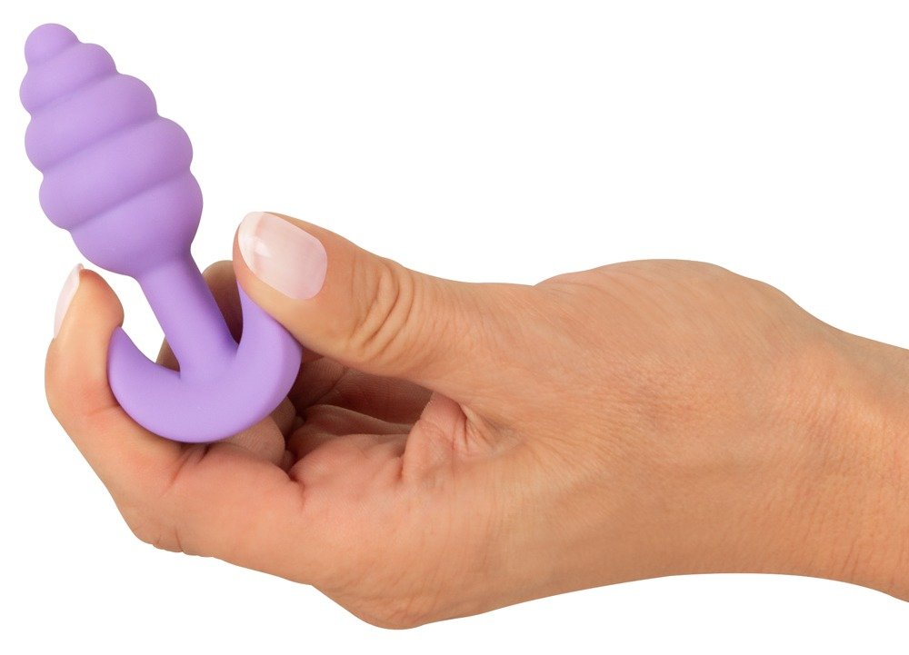 Eine Hand hält ein lila, geripptes Sexspielzeug auf weißem Hintergrund.