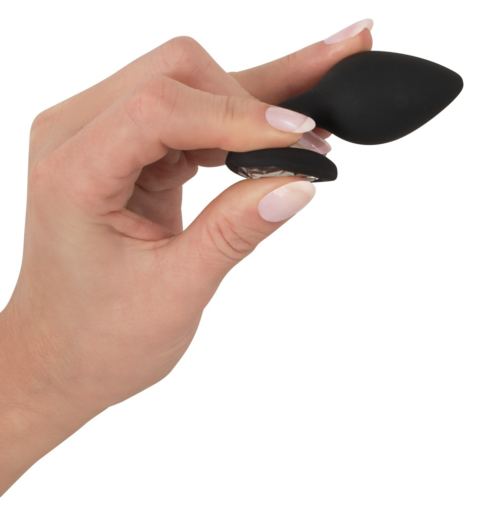 Eine Hand hält ein kleines, schwarzes, tropfenförmiges Sexspielzeug mit einem glitzernden Sockel.