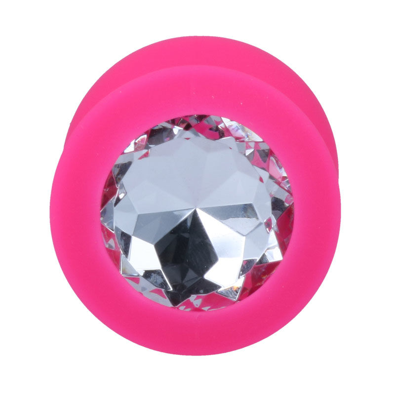 Ein runder, leuchtend pinker Tunnelpiercing mit einem großen, facettierten Glitzerstein in der Mitte auf weißem Grund.