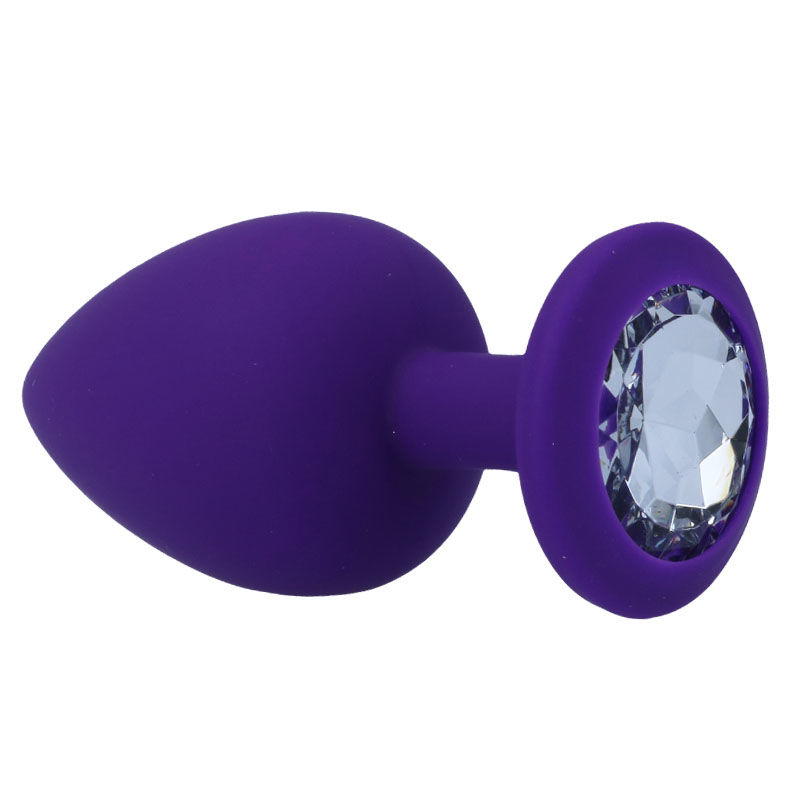 Ein glatter lila Silikon-Analdildo mit einem großen, facettierten, klaren Edelstein in der runden Basis.