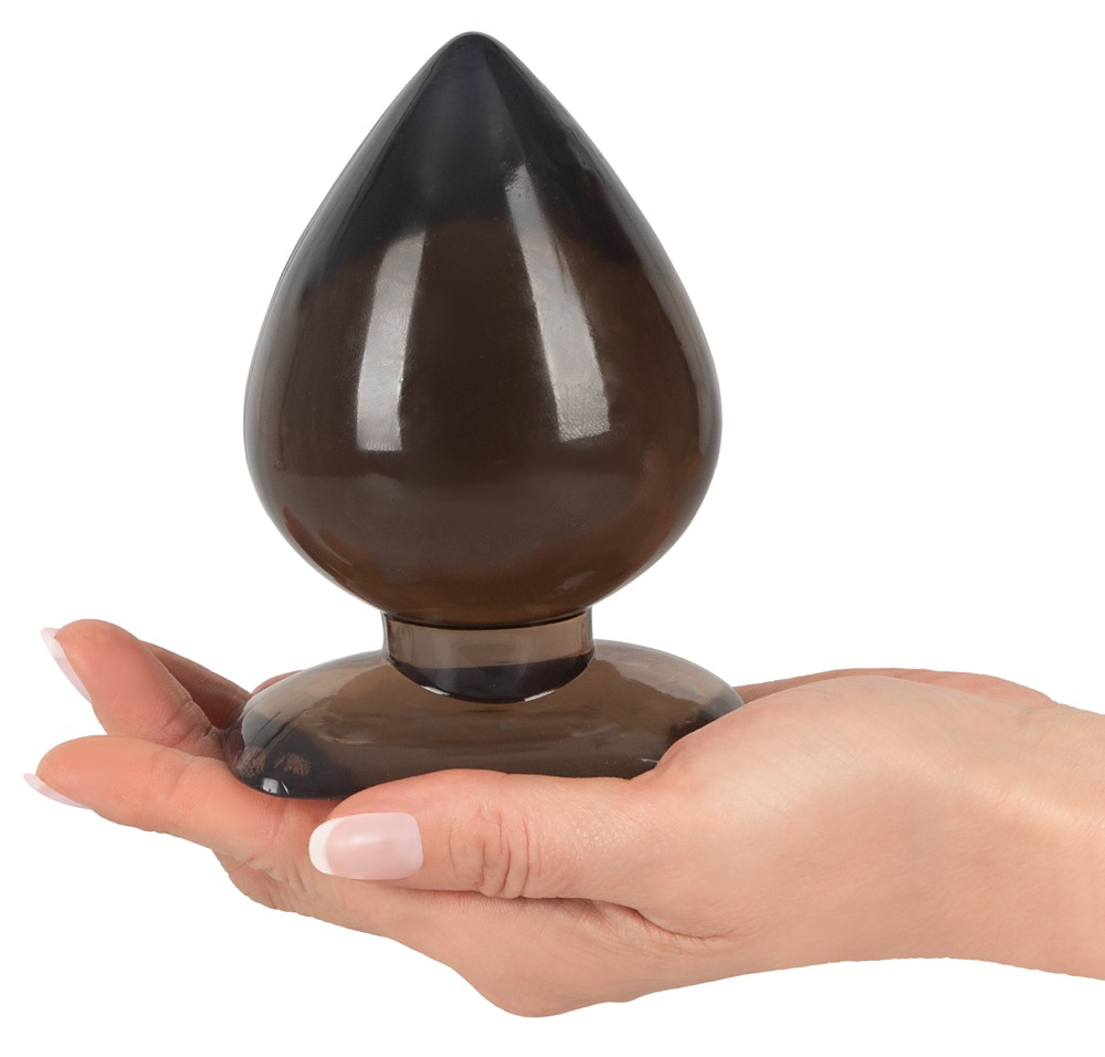 Eine Hand hält ein großes, schwarzes, glänzendes Pllug-Spielzeug mit abgerundeter Spitze und einer breiten Basis.