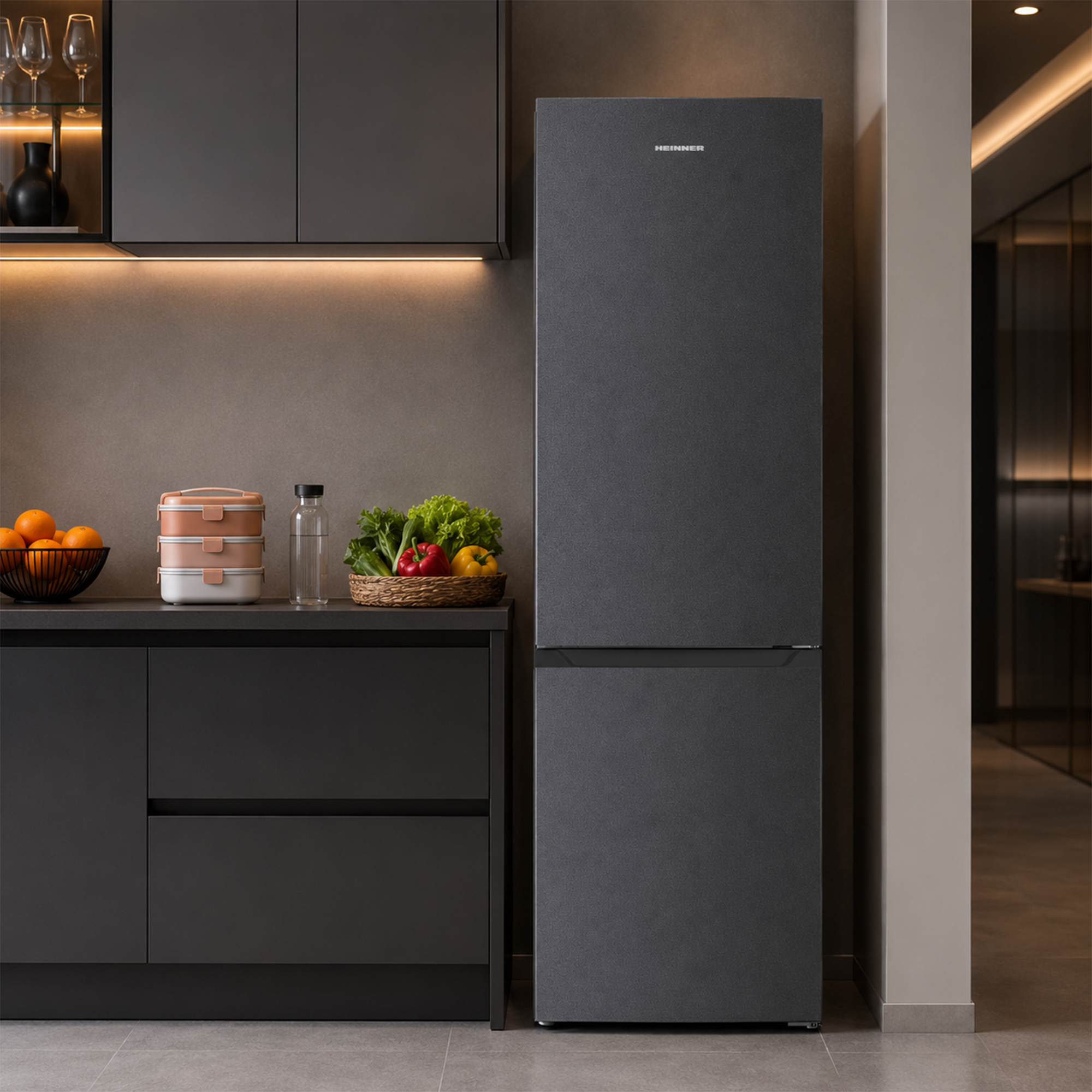 Modern grey kitchen with dark refrigerator, fruit bowl, and vegetable basket on the counter.
