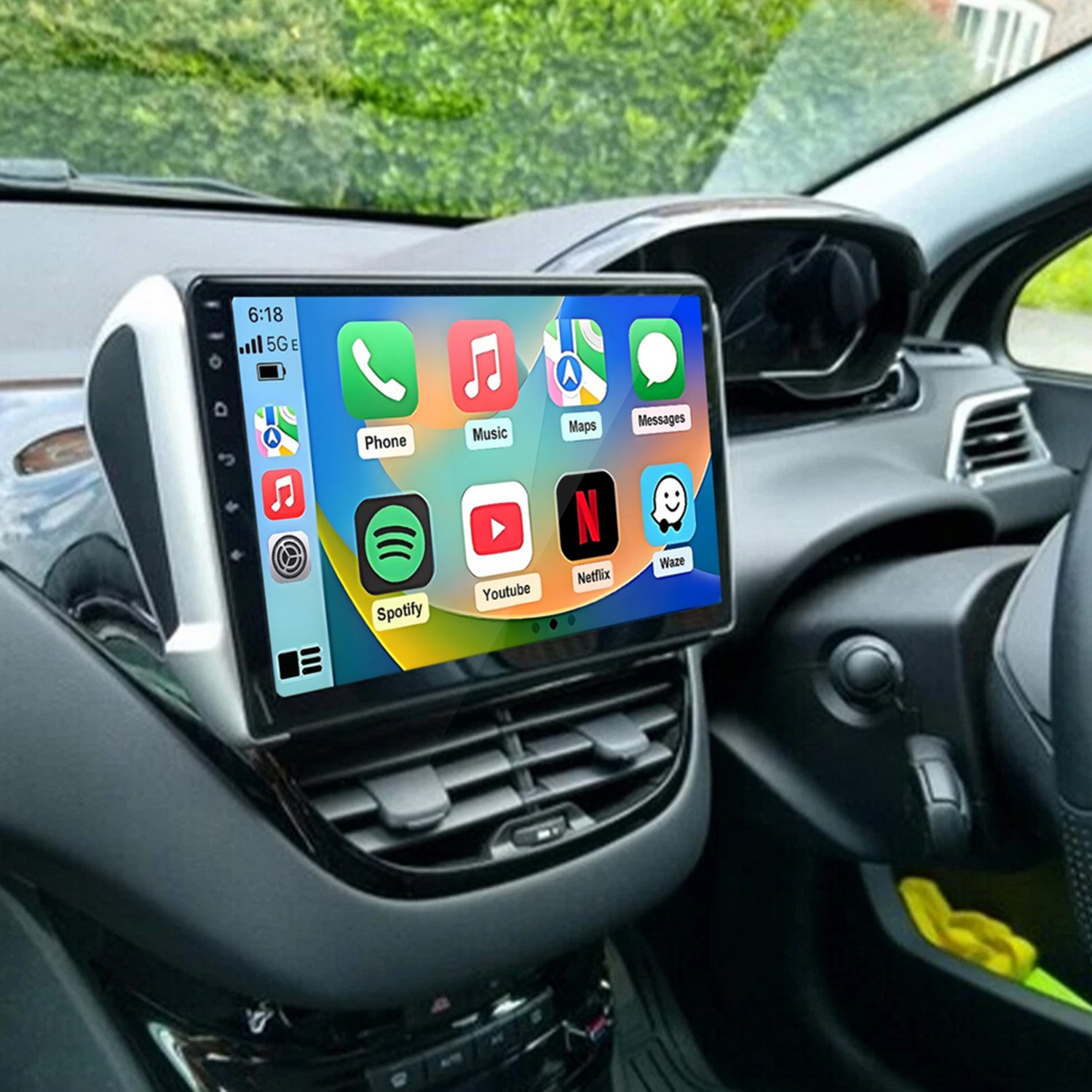 Interni di un'auto con sistema di infotainment touchscreen sul cruscotto che mostra icone di app.