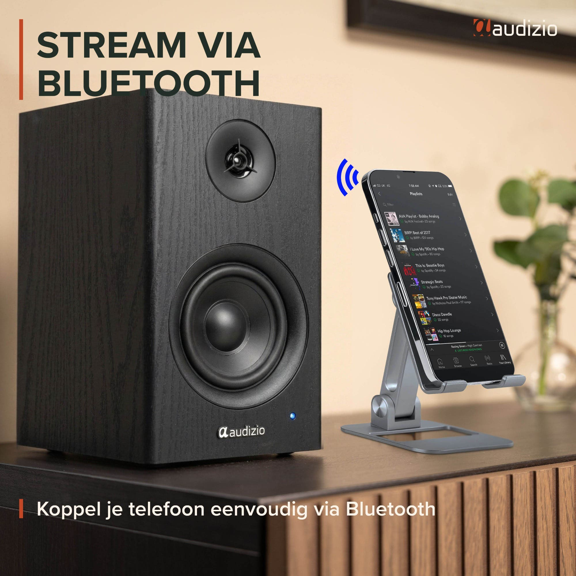 Un altavoz negro Audizio transmite música de forma inalámbrica desde un teléfono inteligente en un soporte.