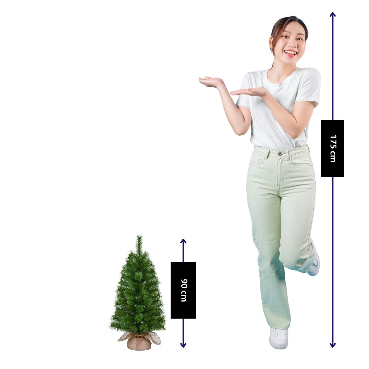A smiling woman (175 cm) gestures toward a small 90 cm Christmas tree.
