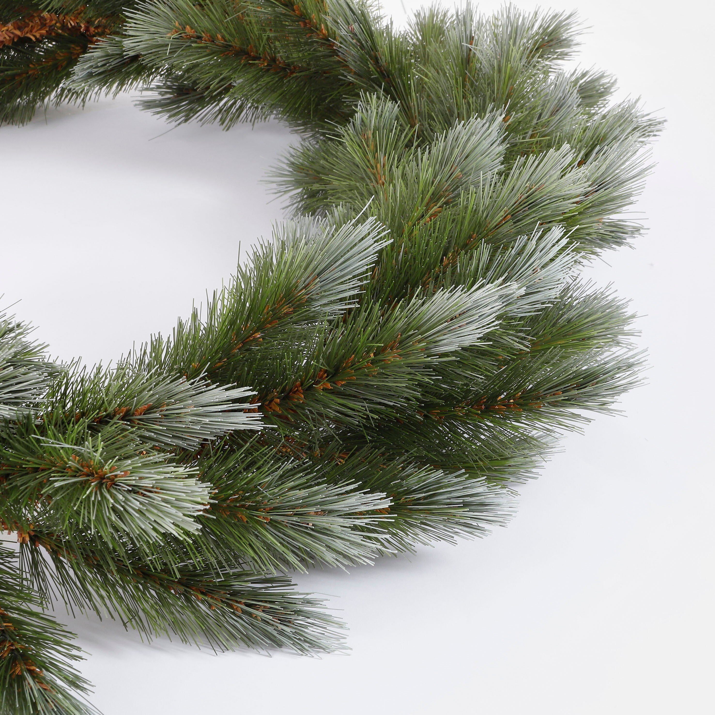 Guirlande de Noël verte et enneigée sur fond clair.