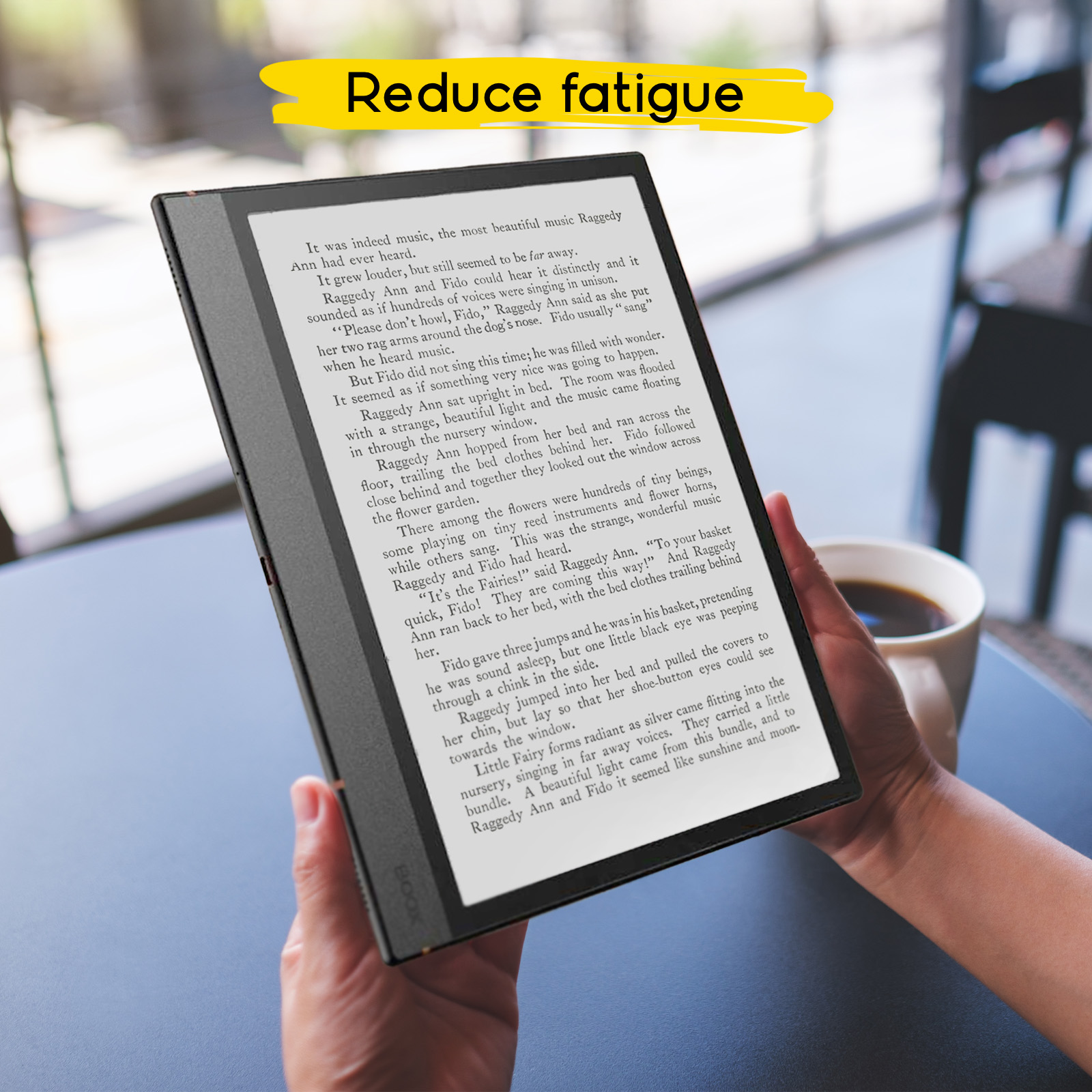 Lector de libros electrónicos con texto sostenido por manos, con una taza de café en una mesa oscura.
