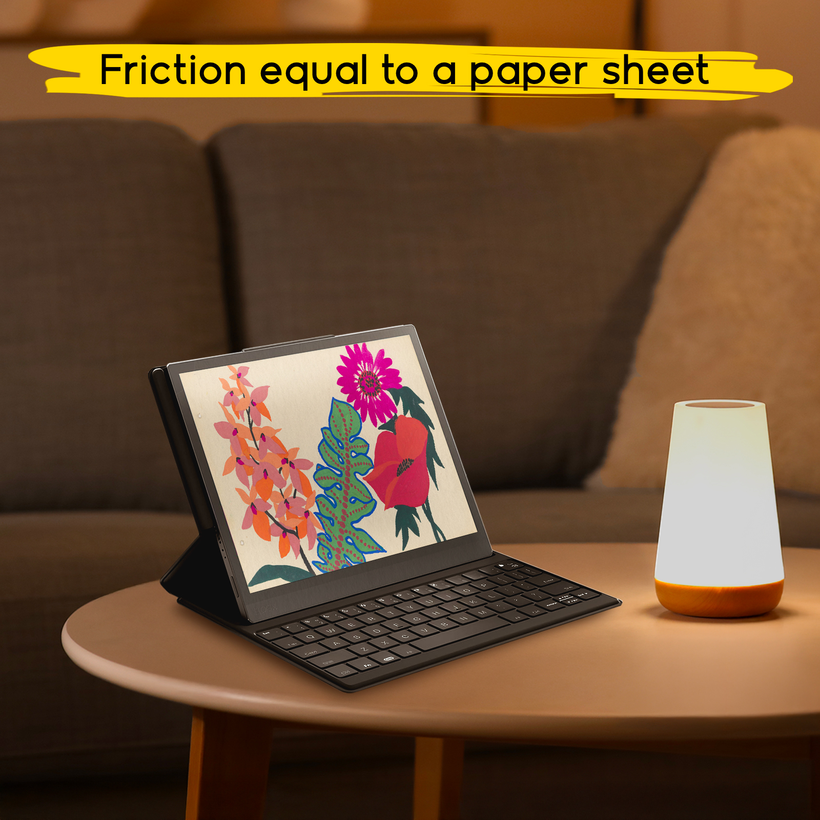 Una tableta con teclado y arte floral en la pantalla se encuentra junto a una lámpara en una mesa en una sala.