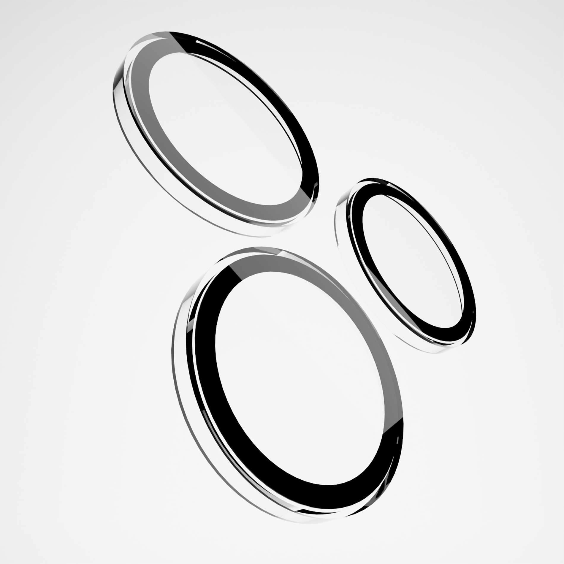 Tres anillos circulares negros y plateados brillantes flotan sobre fondo blanco.