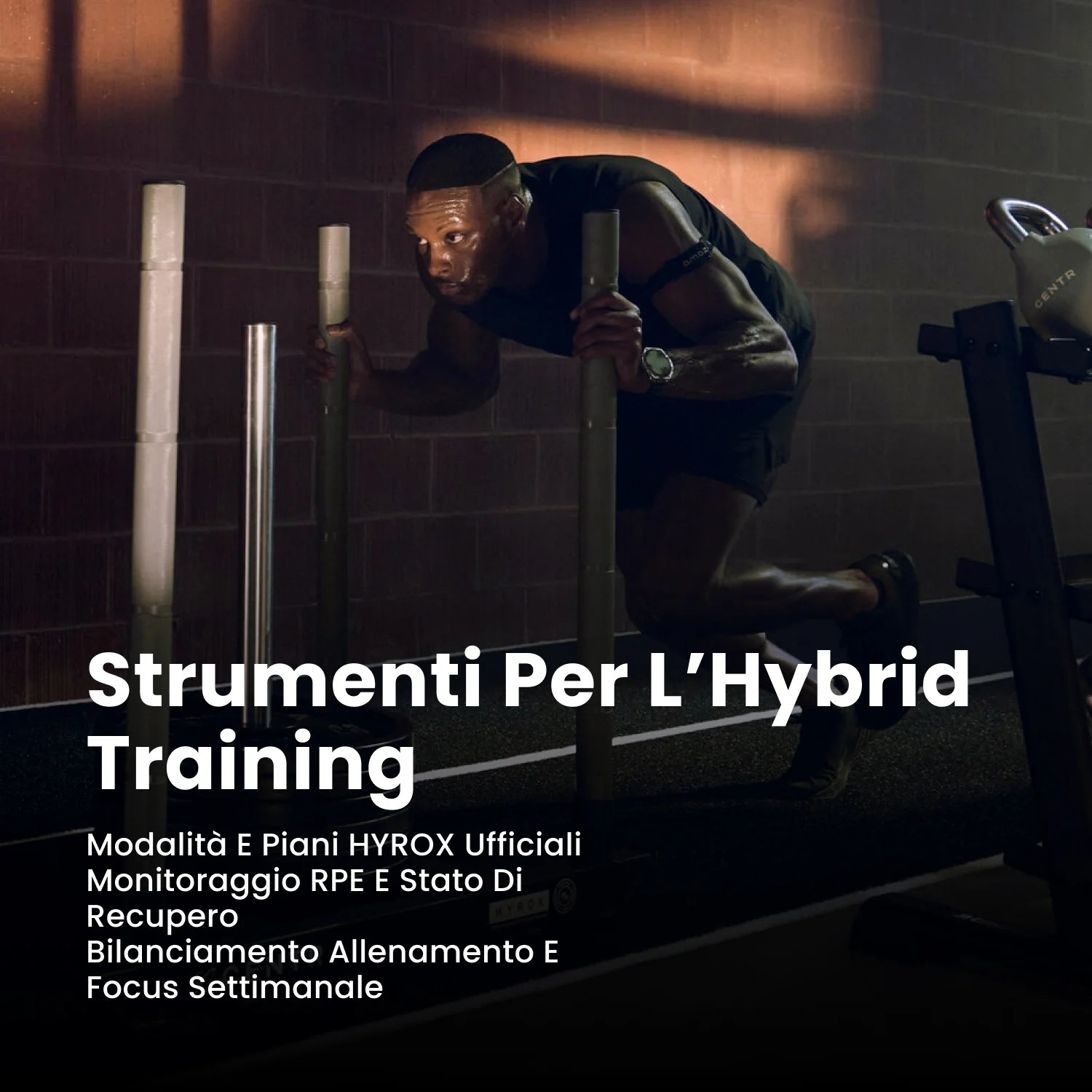 Ein Mann schiebt einen schweren Schlitten in einem schwach beleuchteten Fitnessstudio mit Backsteinwänden.