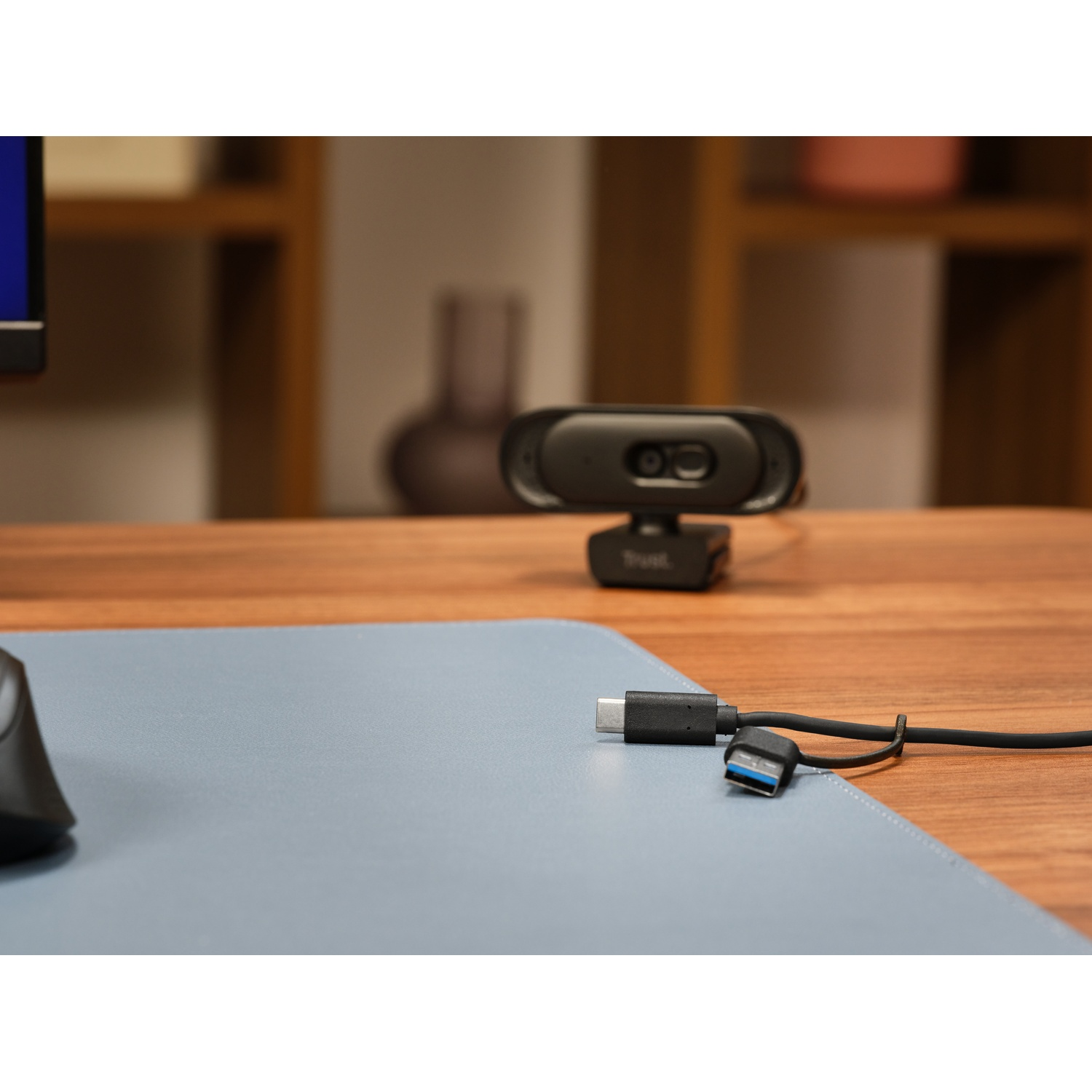 Eine Webcam auf dem Holztisch mit USB-Kabel im Vordergrund.