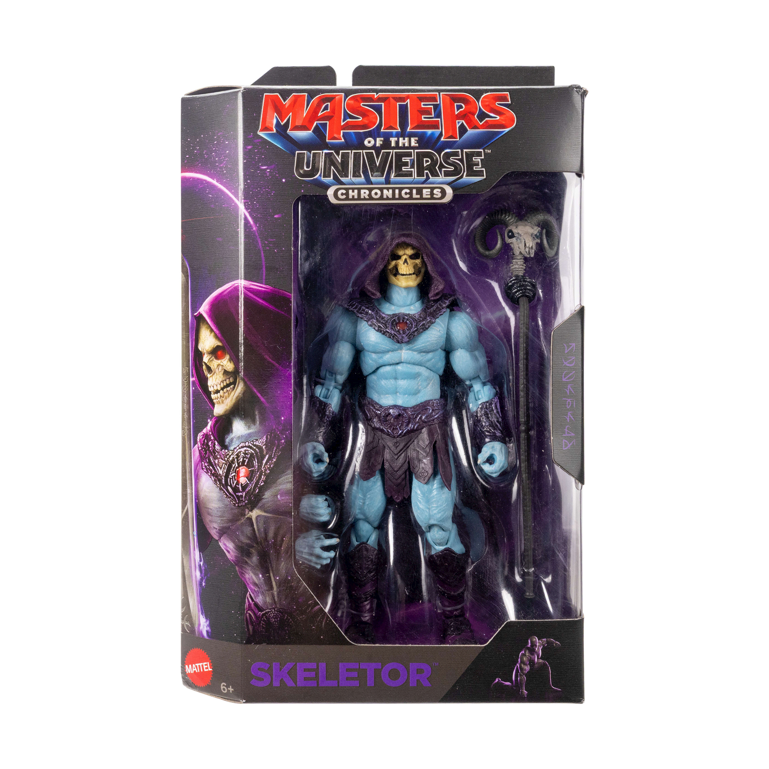 Figura de acción de Skeletor en su caja con bastón sobre fondo morado.