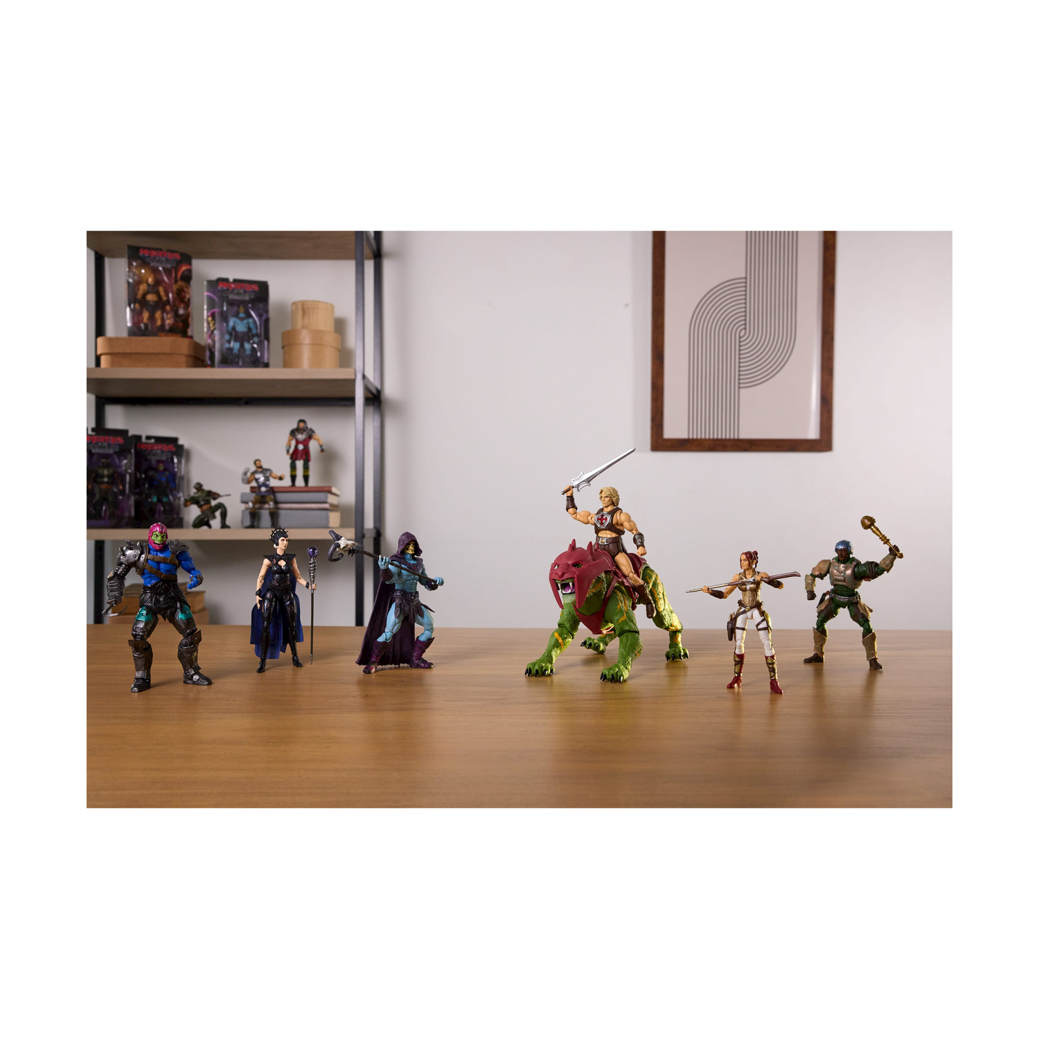 Las figuras de acción, incluidos Skeletor y He-Man en una bestia verde, se encuentran en una mesa de madera.