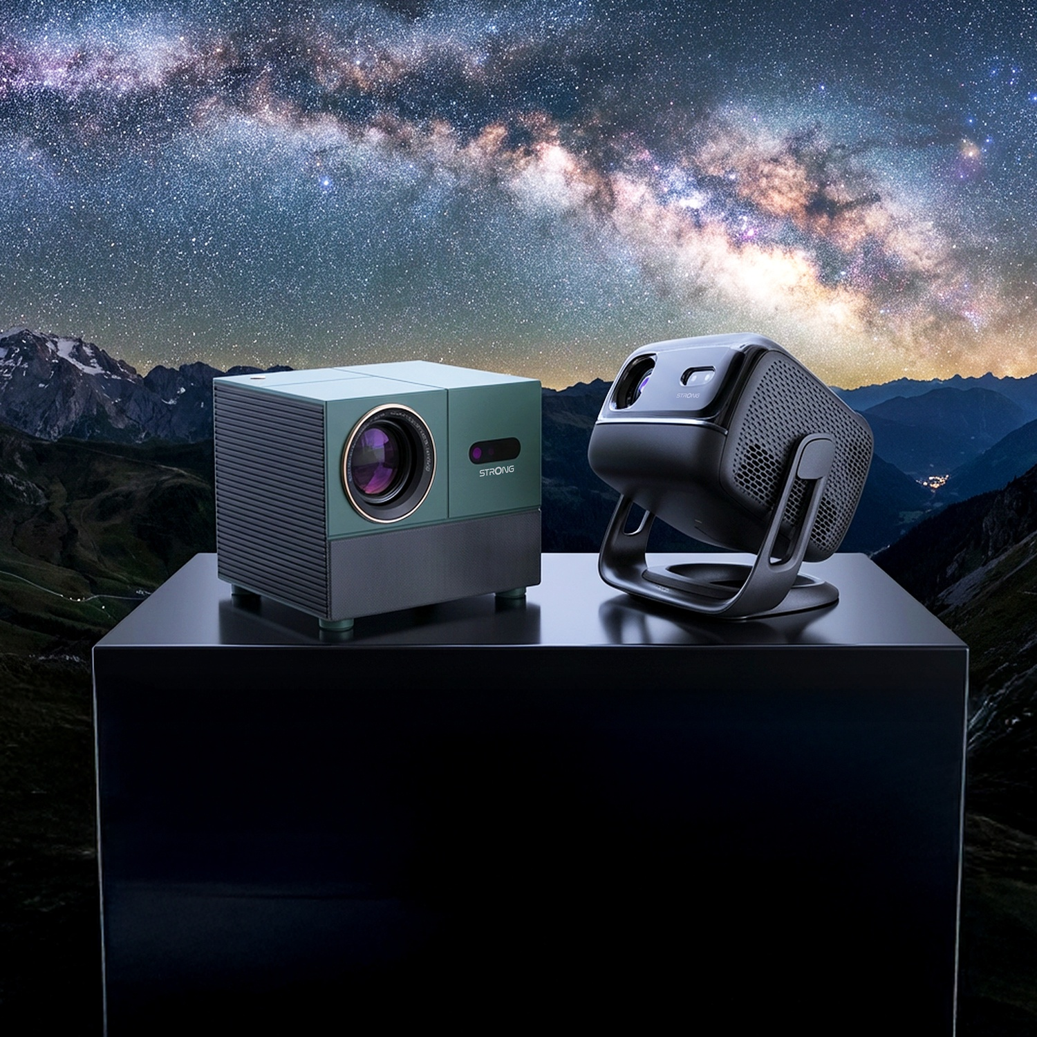 Due proiettori sono su un tavolo di fronte a un paesaggio montano e a un cielo notturno stellato.