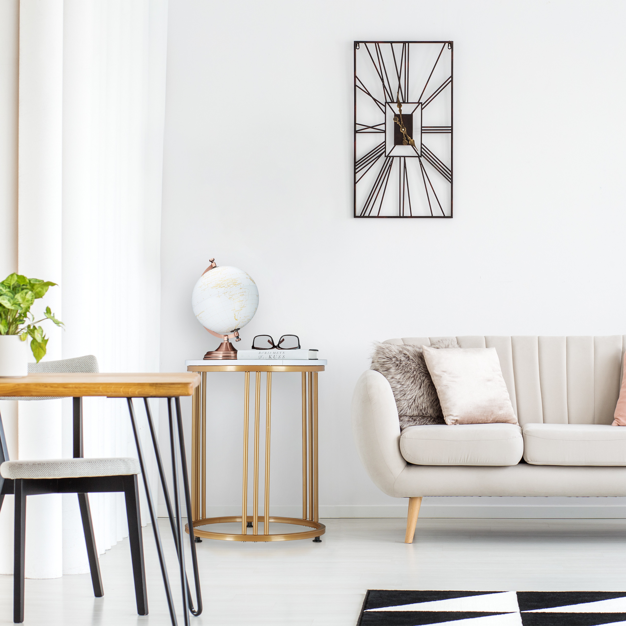 Wohnzimmer mit beigem Sofa, goldenem Beistelltisch mit Globus, Holztisch und großer Wanduhr auf weißem Hintergrund.