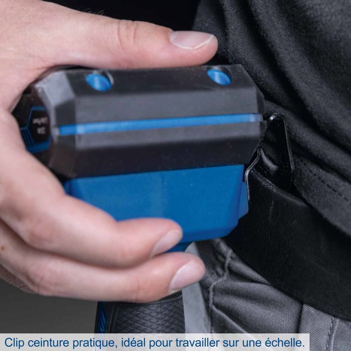 Hand befestigt ein blaues Gerät an einem schwarzen Gürtel.
