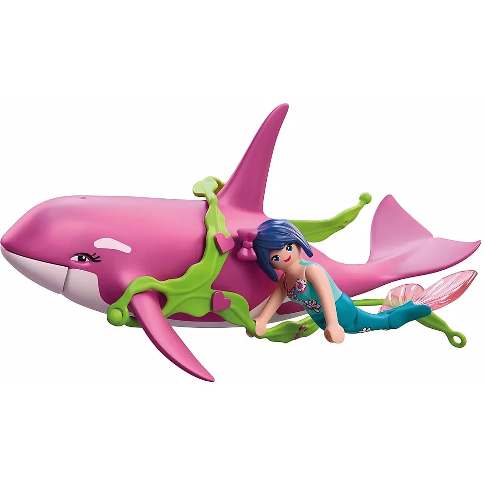 Una sirena de juguete con cabello azul nada junto a una gran orca rosa envuelta en algas verdes.