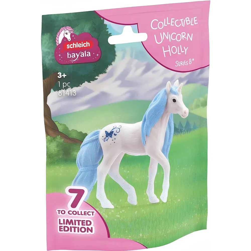 Schleich Bayala Sammelfigur Schachtel mit Einhorn Holly auf einer Wiese mit Bergen im Hintergrund.