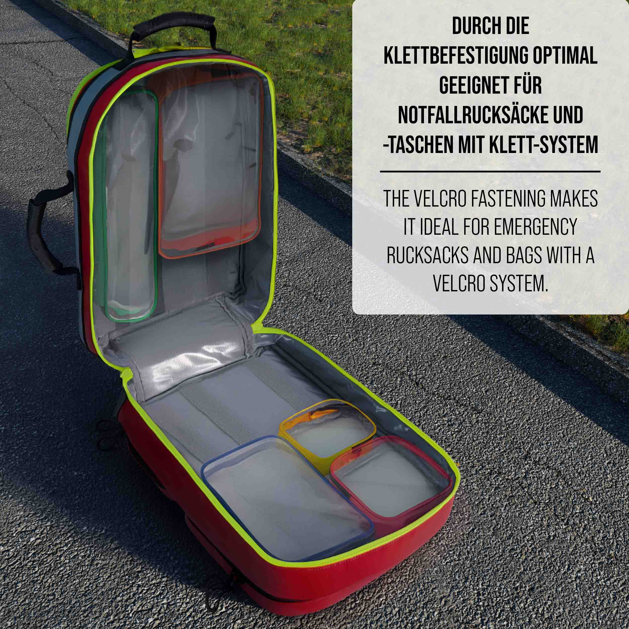 Geöffneter roter Rucksack mit transparenten Fächern und Klettverschluss auf Asphalt.